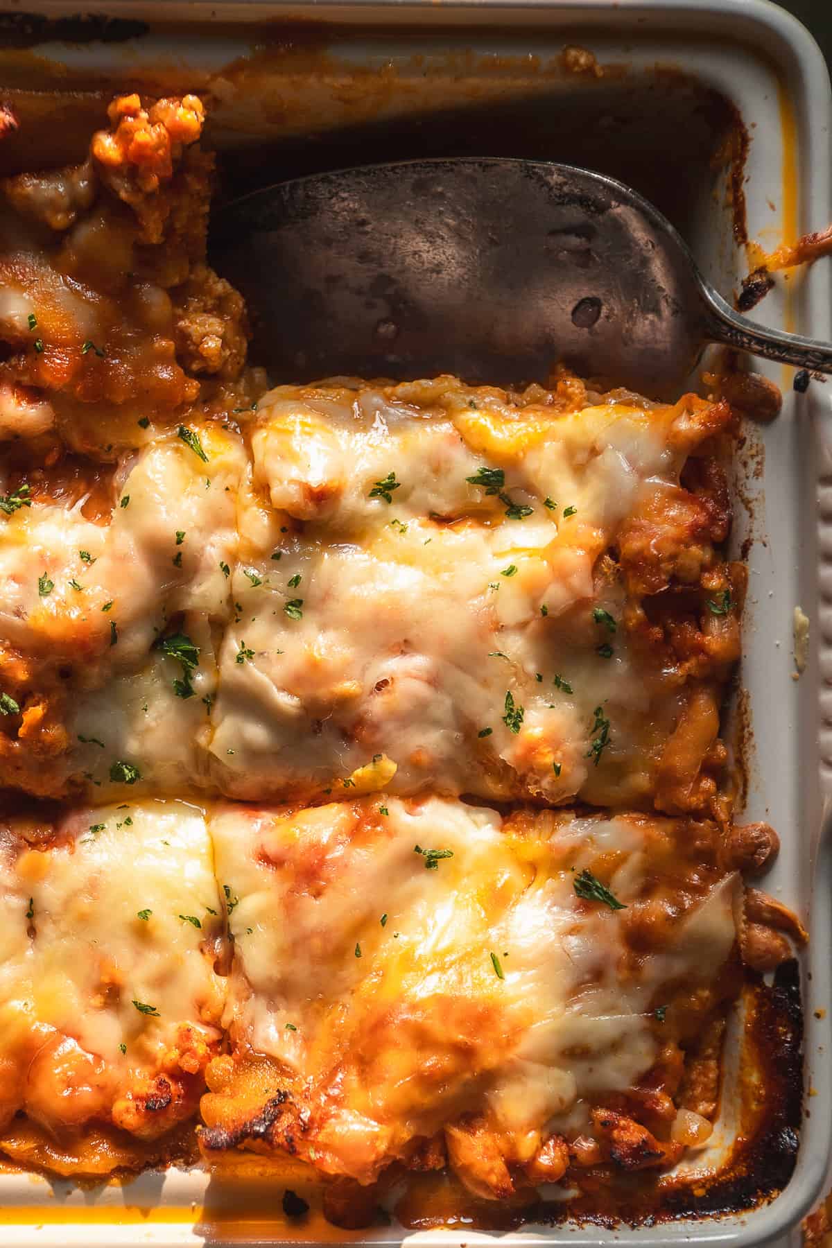 Gluten free lasagna in a baking dish with cheese on top.