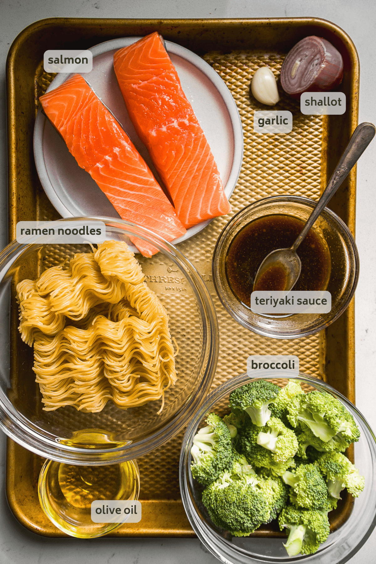 Teriyaki salmon noodles ingredients on a gold baking sheet.