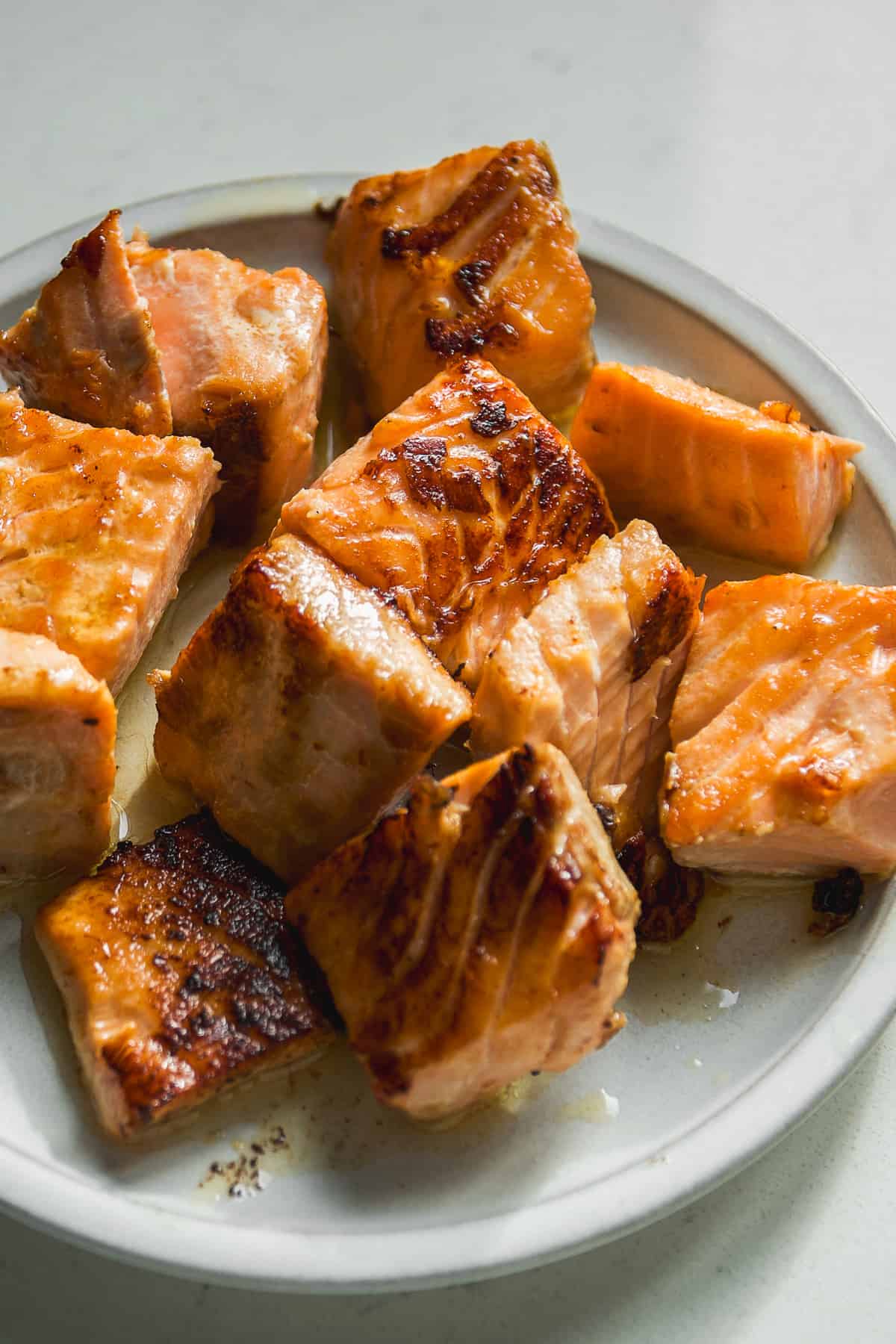 Teriyaki salmon bites on a plate.