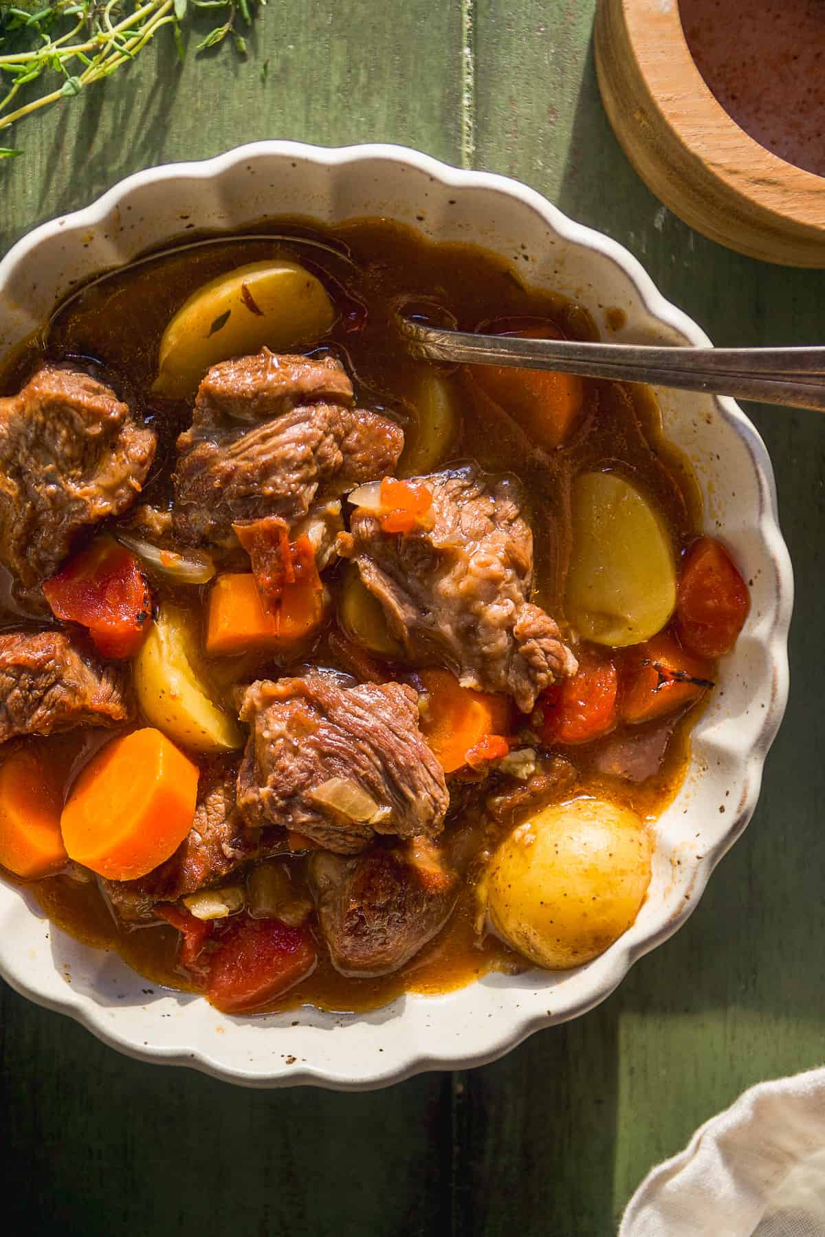 Bowl of healthy beef stew with a spoon resting inside.