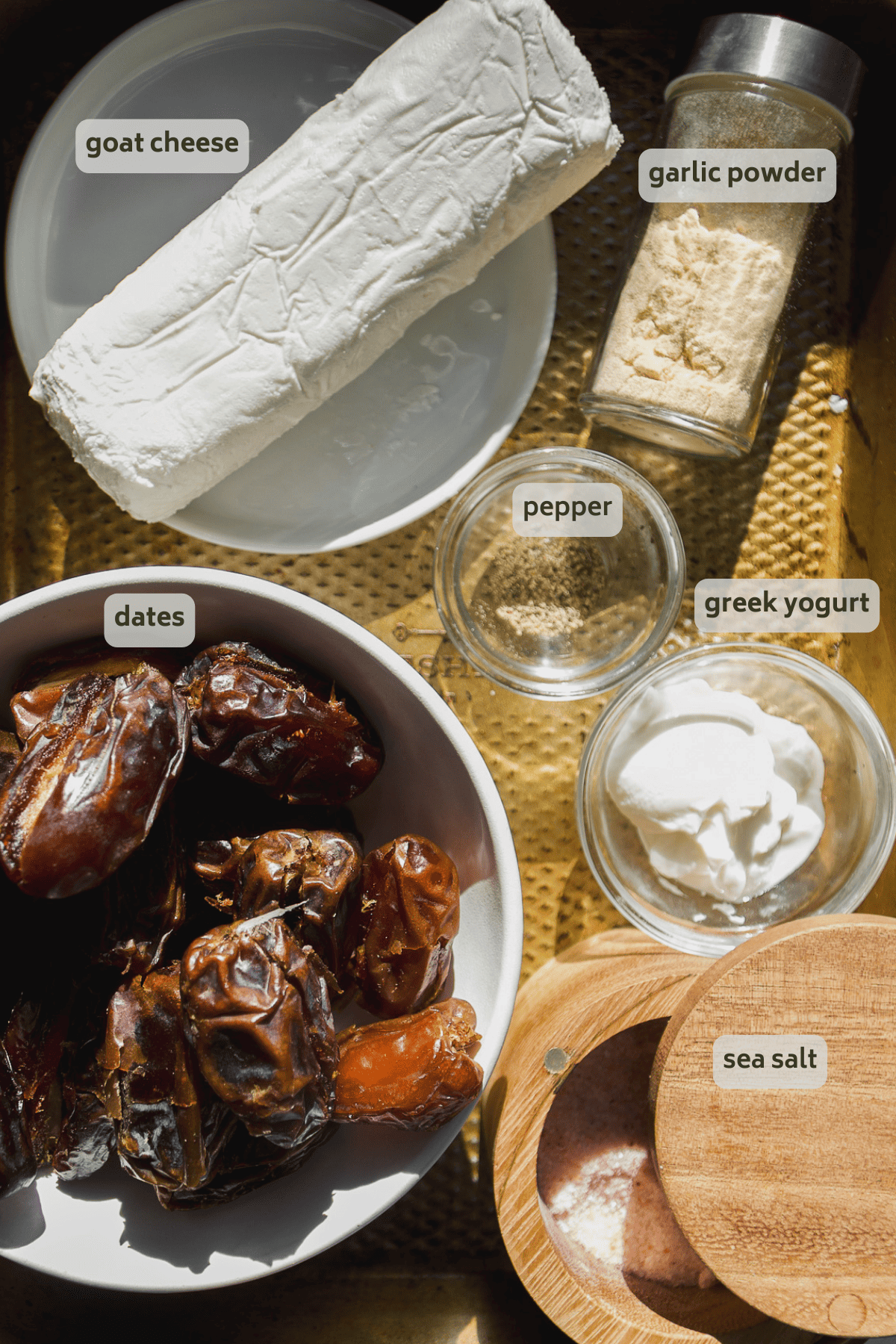 Goat cheese stuffed dates ingredients on a baking sheet.