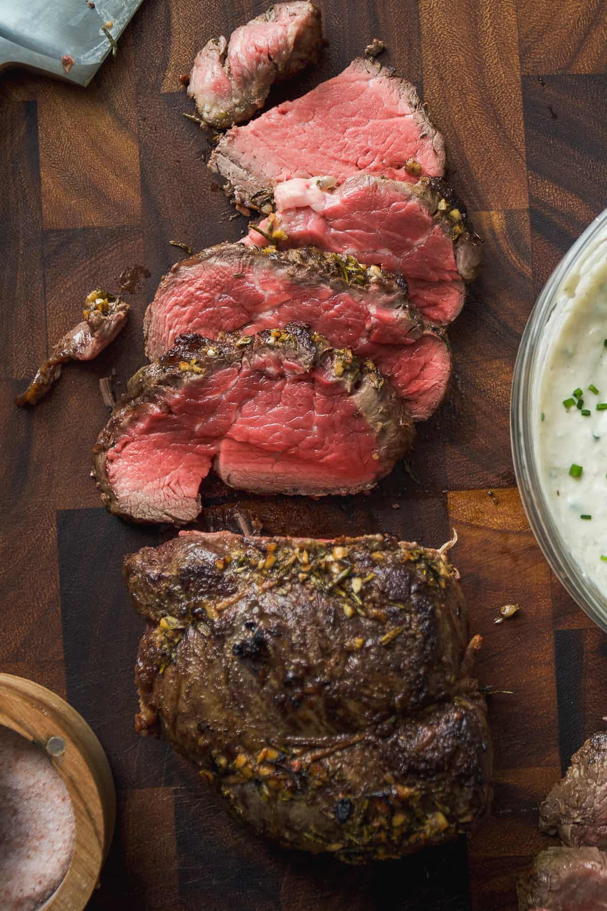 Slices of beef tenderloin on a cutting board.