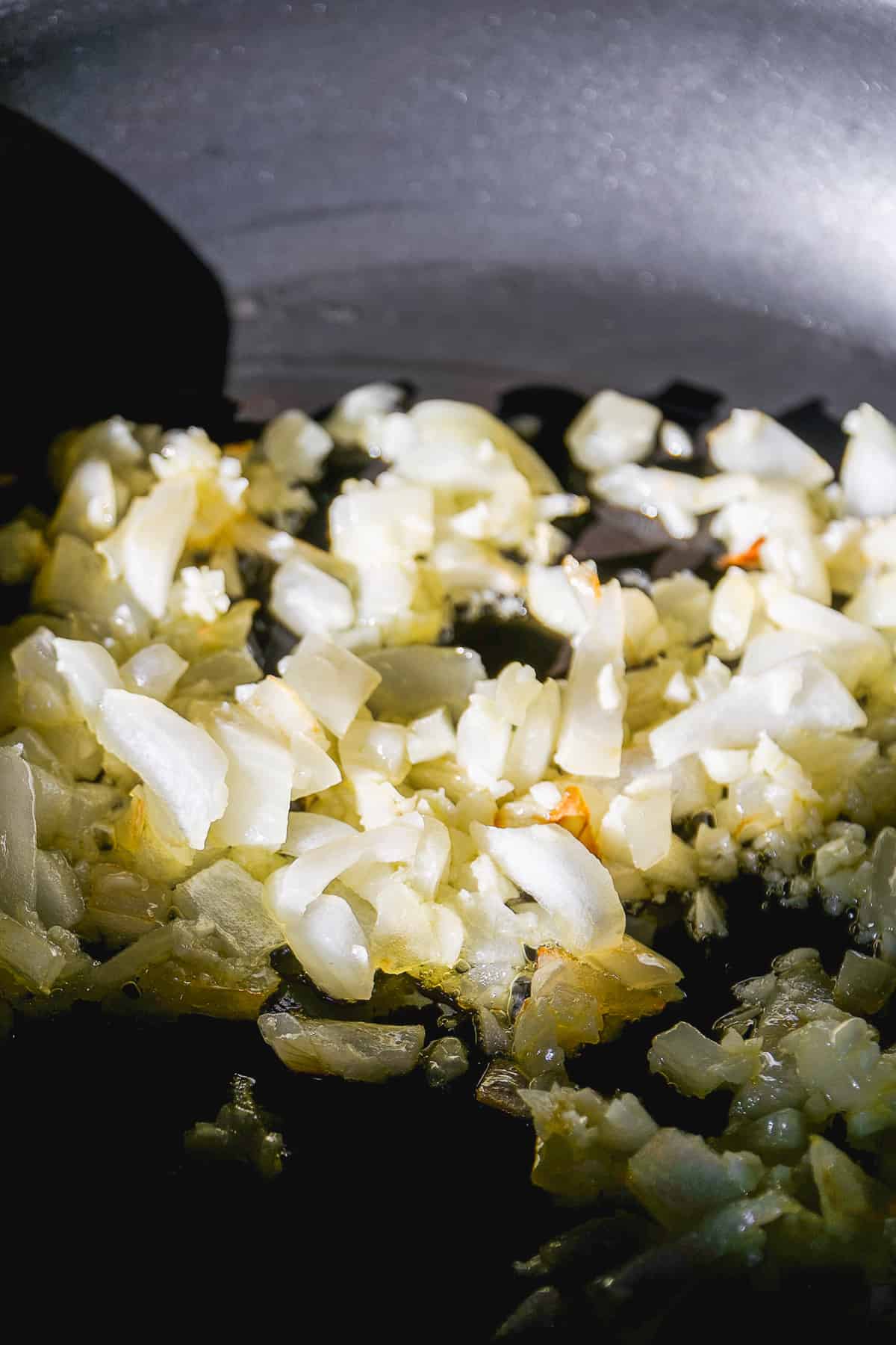 Onions and garlic cooked in a skillet with oil.