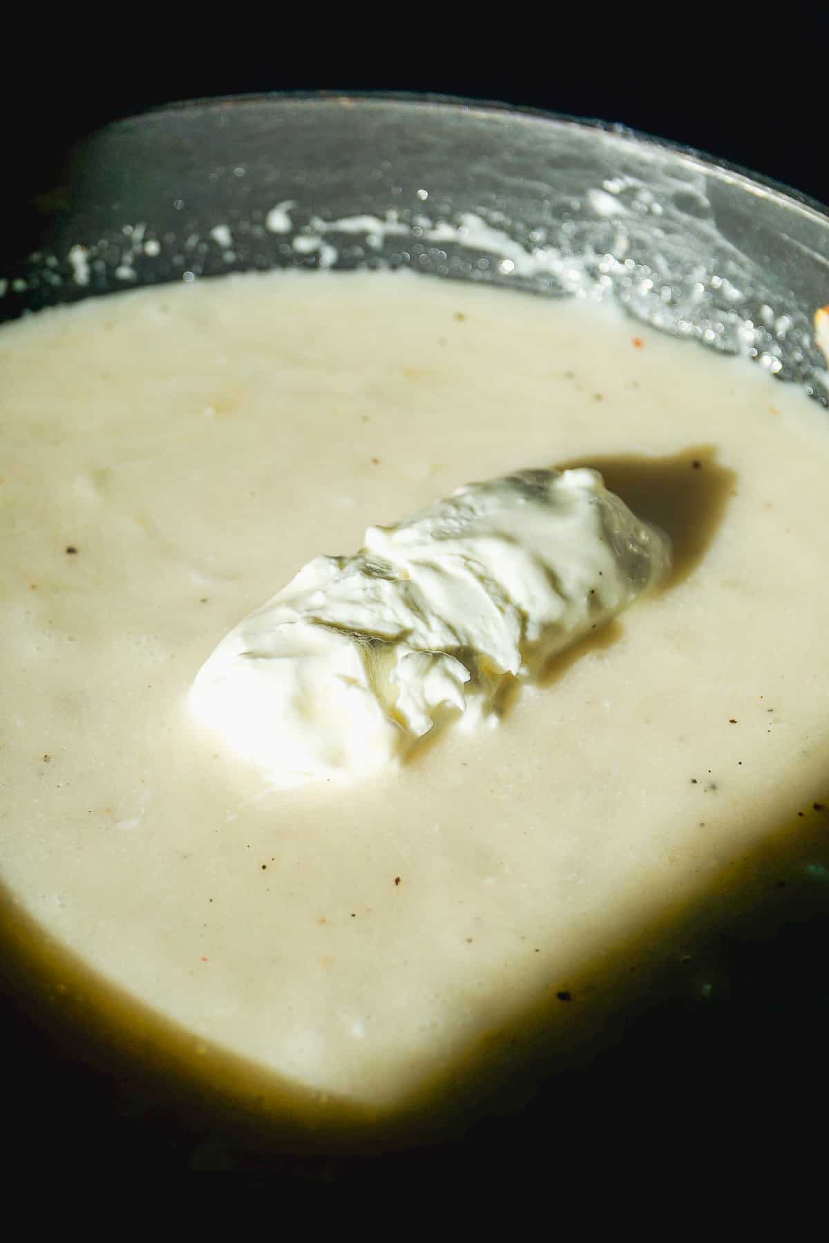 Goat cheese melting into s milk based sauce.
