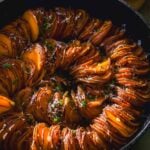 Scalloped sweet potatoes in a spiral cooked in a cast iron skillet.