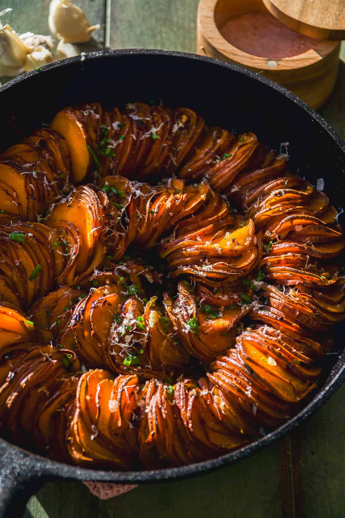 Scalloped sweet potatoes in a spiral cooked in a cast iron skillet.