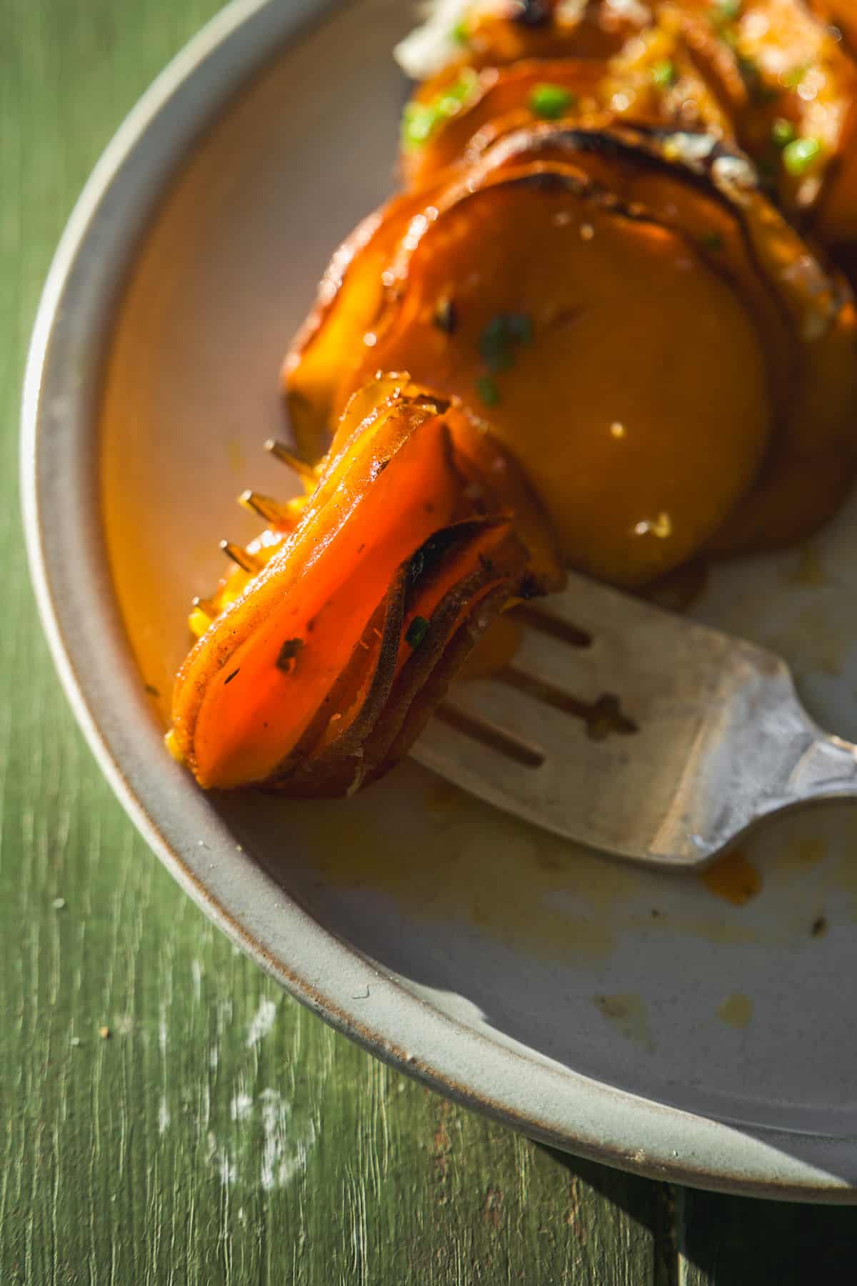 Scalloped sweet potatoes on a fork.