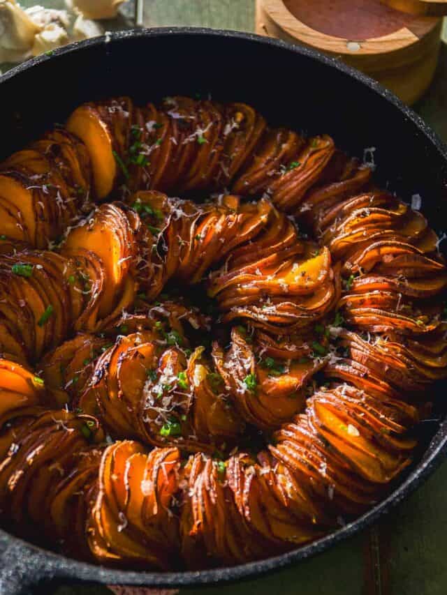Scalloped sweet potatoes in a spiral cooked in a cast iron skillet.