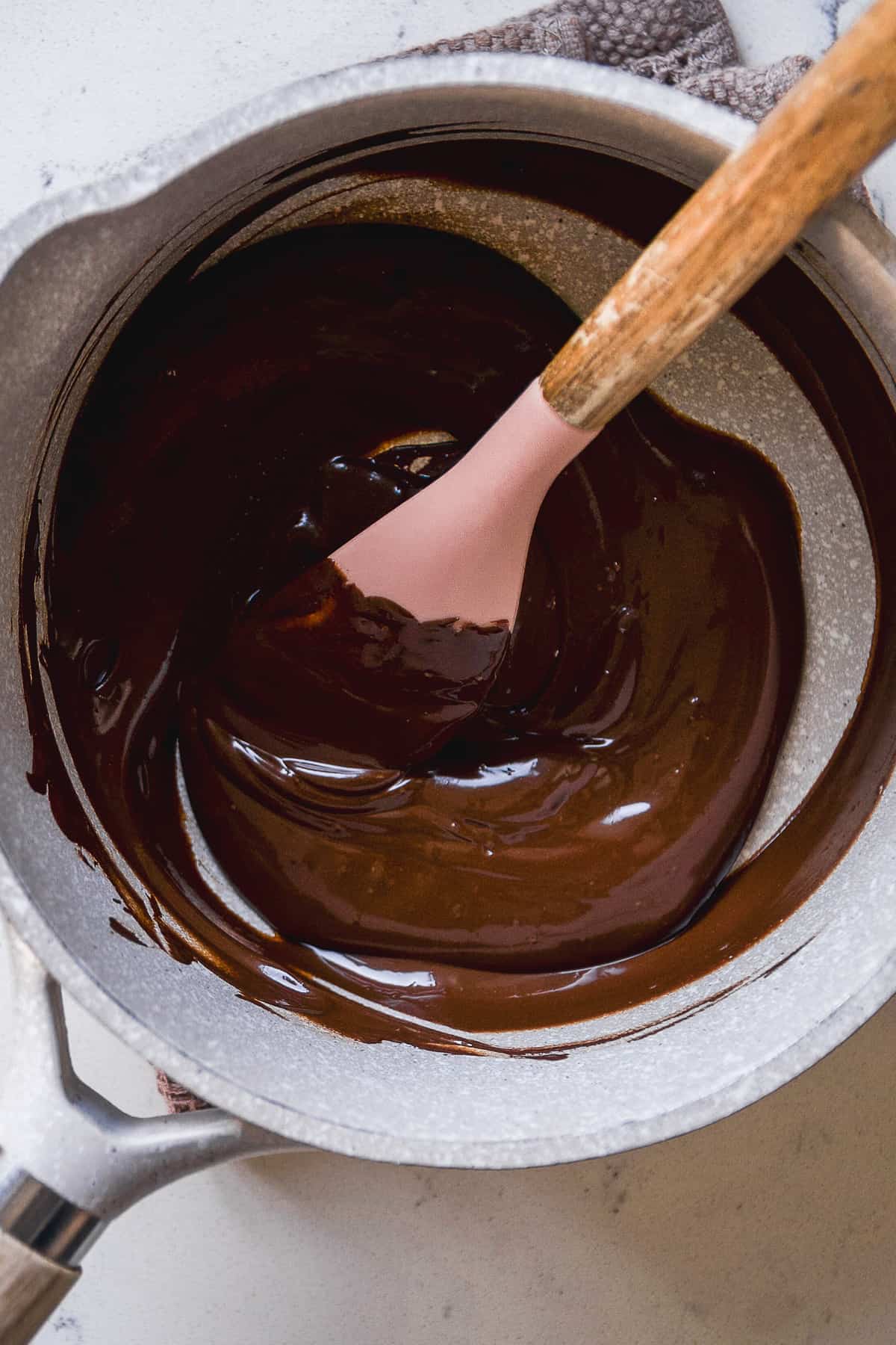 Chocolate melted in a pot with a spatula.