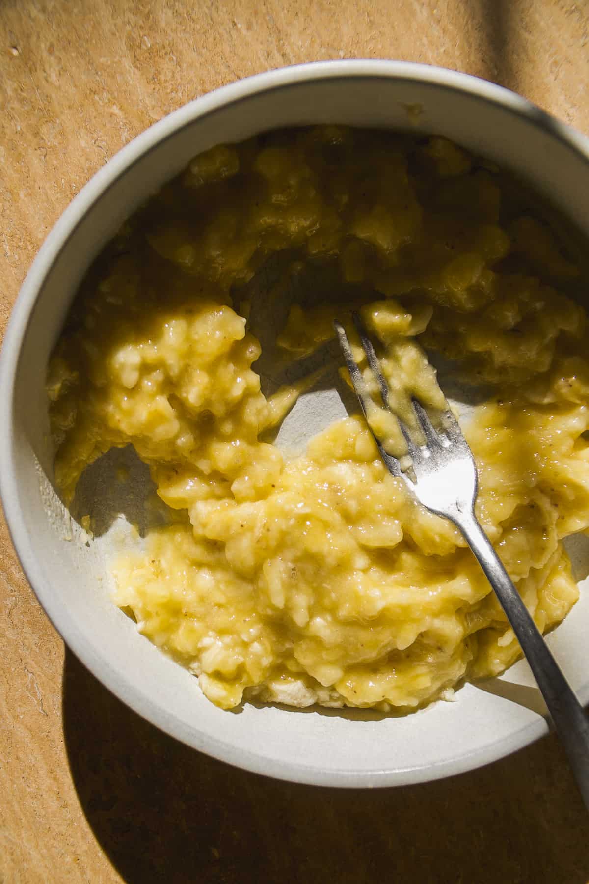 Mashed bananas in a plate with a fork.