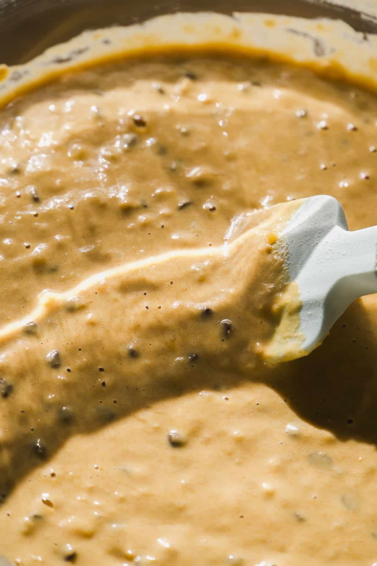 Oat flour banana bread batter with chocolate chips in a bowl.