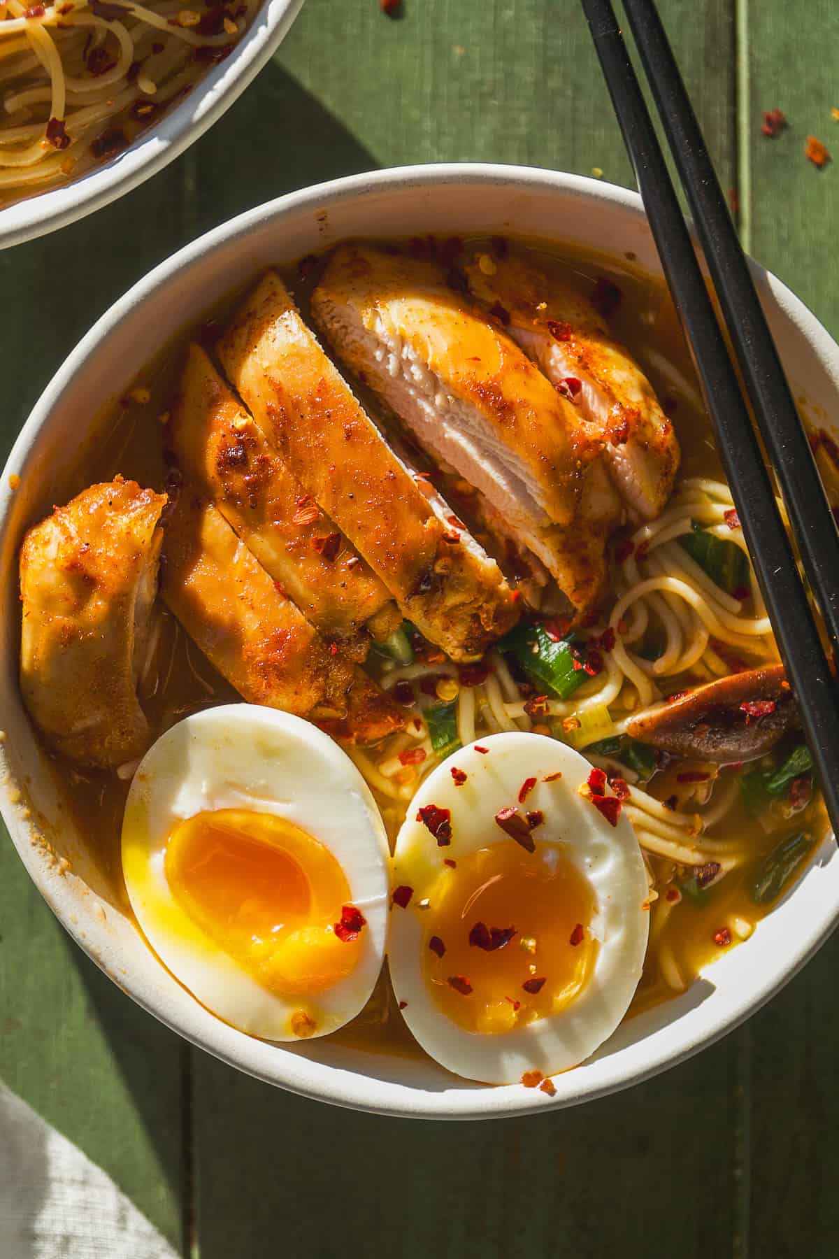 Overhead view of a bowl with chicken ramen noodles and a soft boiled egg.