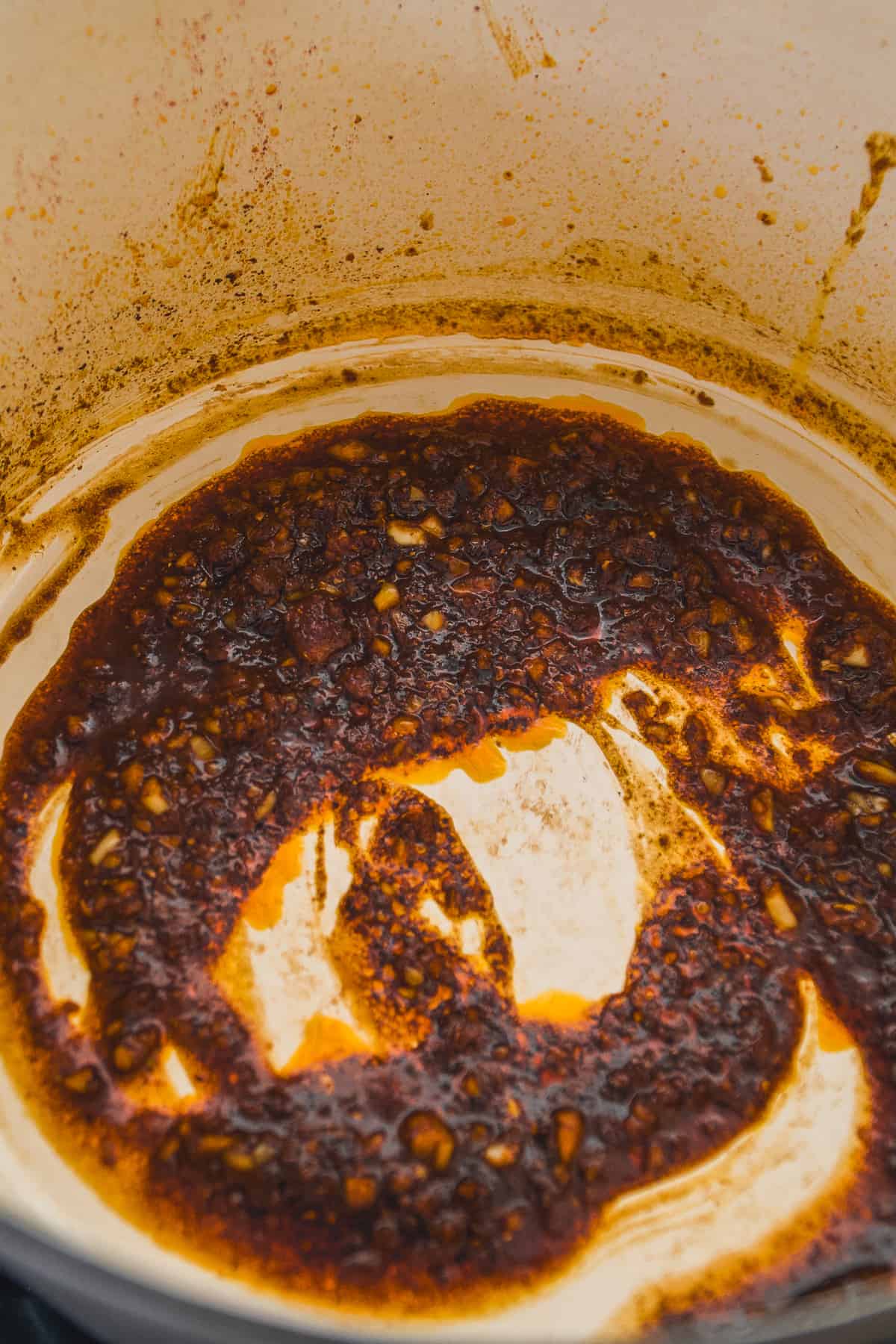 Ginger and garlic simmering the bottom of a pot.