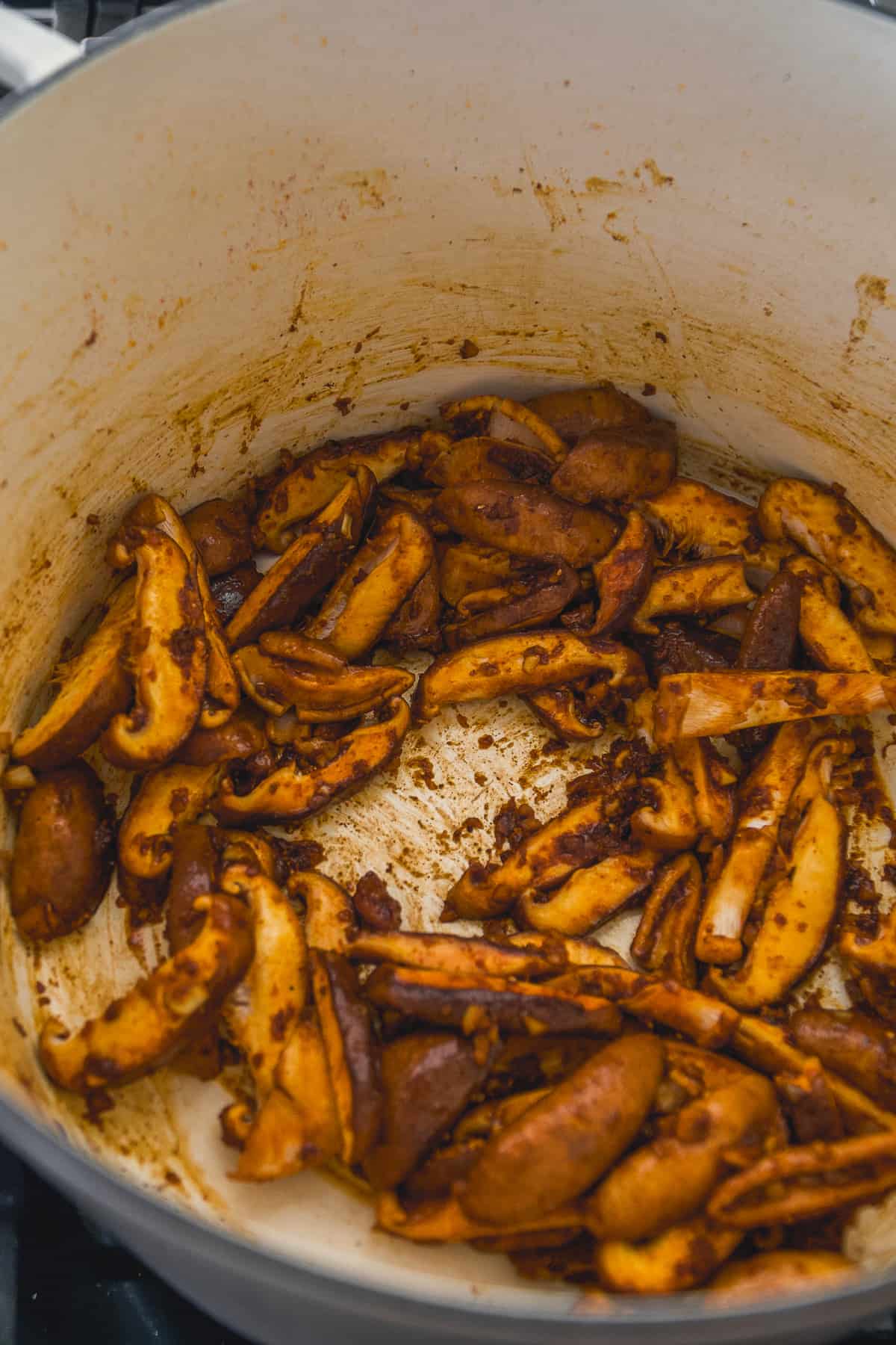 Mushrooms simmering a pot with spices.