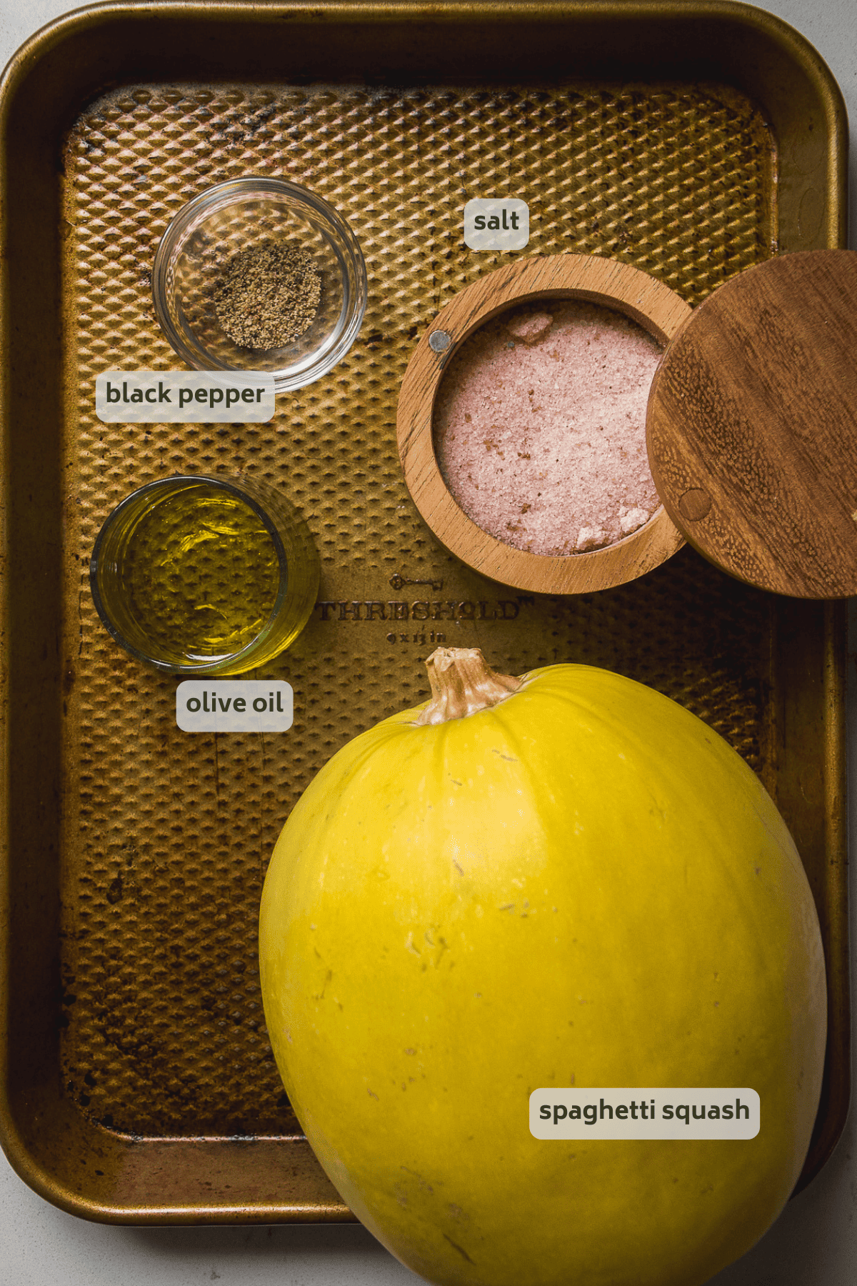 Roasted spaghetti squash ingredients on a gold baking pan with labels.