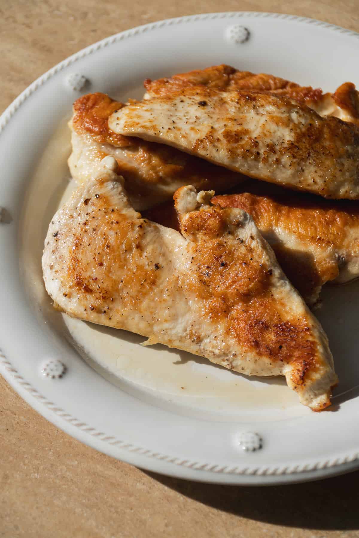 Seared chicken breast on a plate.