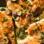 Chicken marsala in a skillet with mushrooms.