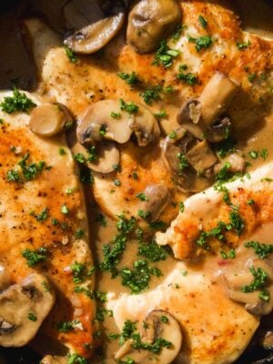 Chicken marsala in a skillet with mushrooms.