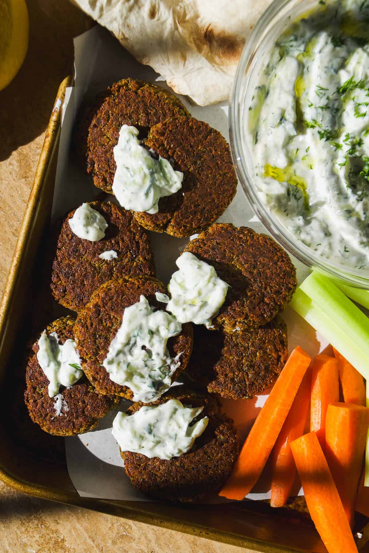 Falafel made with canned chickpeas on a platter with tzatziki sauce.