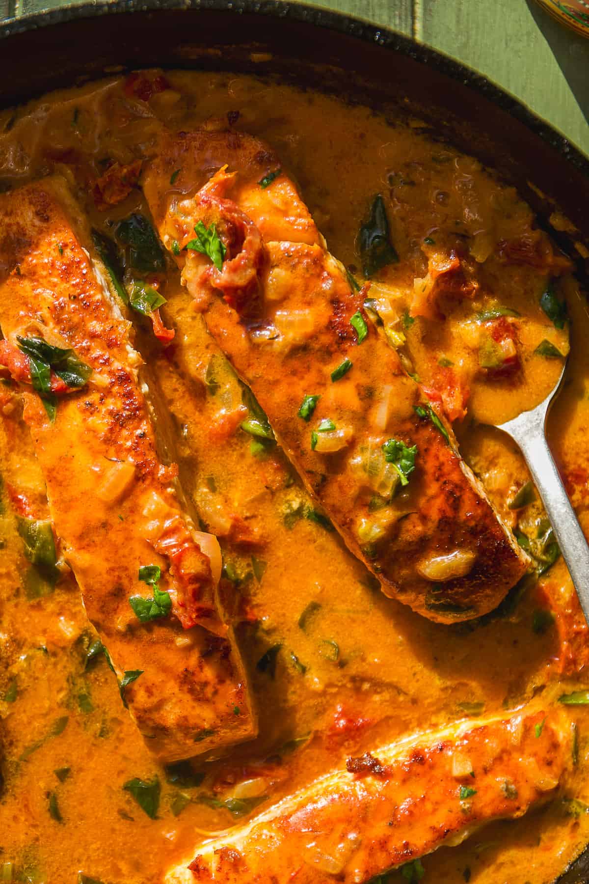 Overhead view of tuscan salmon with sauce in a skillet.