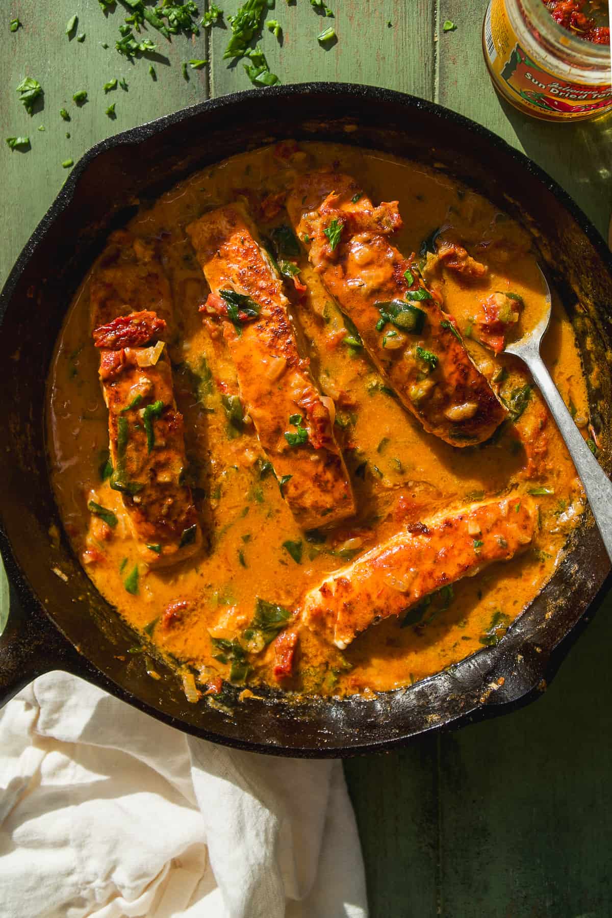 Tuscan salmon in a tomato sauce in a cast iron skillet.