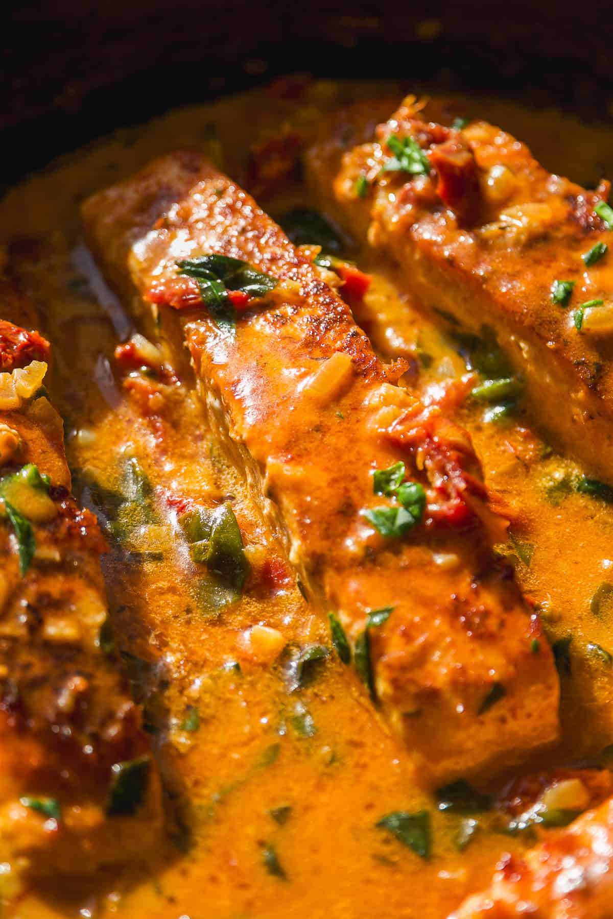 Tuscan salmon in a sauce in a cast iron skillet.