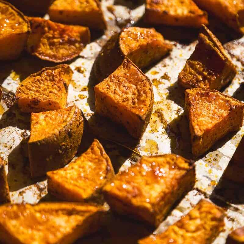 Roasted sweet potato cubes on a baking sheet.