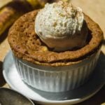 Banana cake in a mug with ice cream on top.