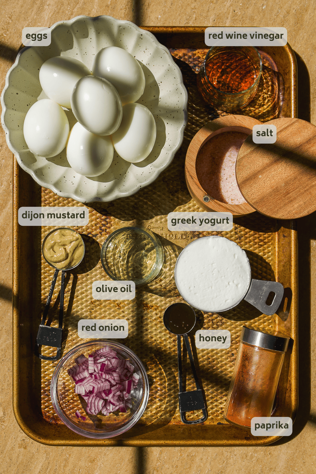 Deviled egg ingredients on a baking sheet.