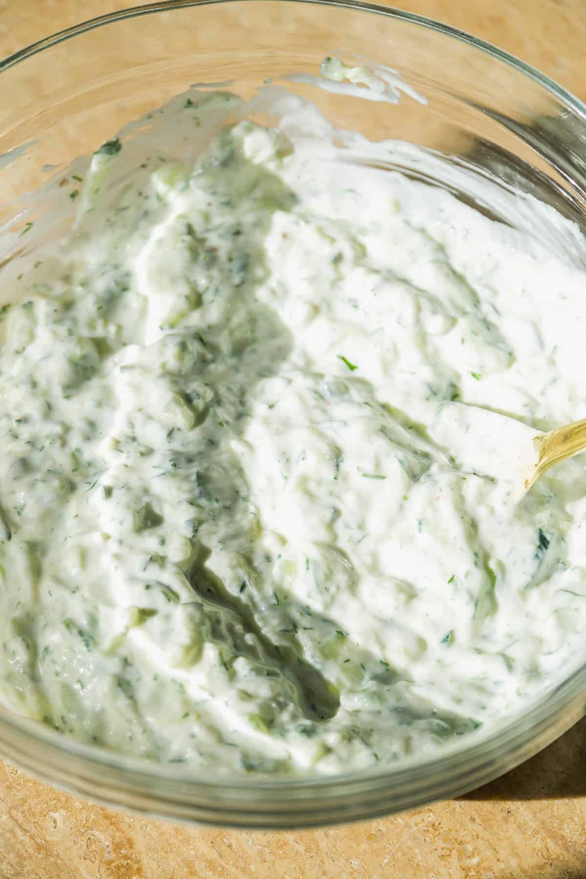 Tzatziki mixed together in a glass bowl.
