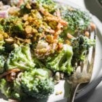 Creamy crunchy broccoli salad on a plate with a fork.