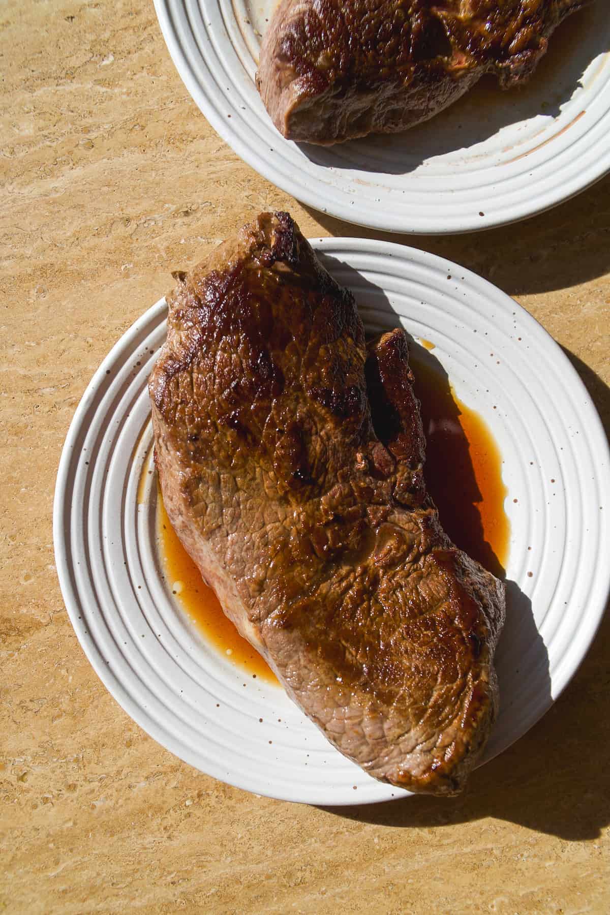Seared steak on a plate resting.