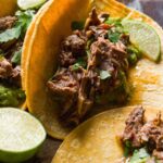 Barbacoa tacos in corn tortillas with guacamole.