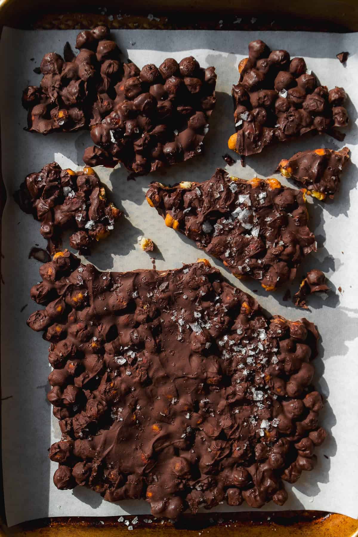 Chocolate covered chickpea bark on parchment paper.