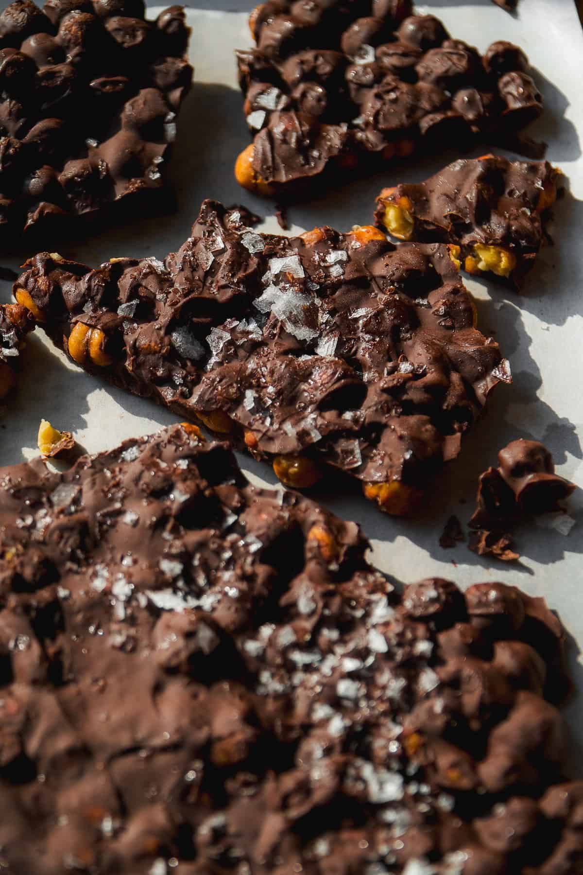 Chickpeas covered in chocolate broken into pieces on a pan.