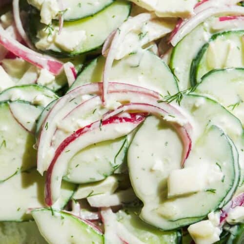 Up close view of creamy cucumber salad with feta.