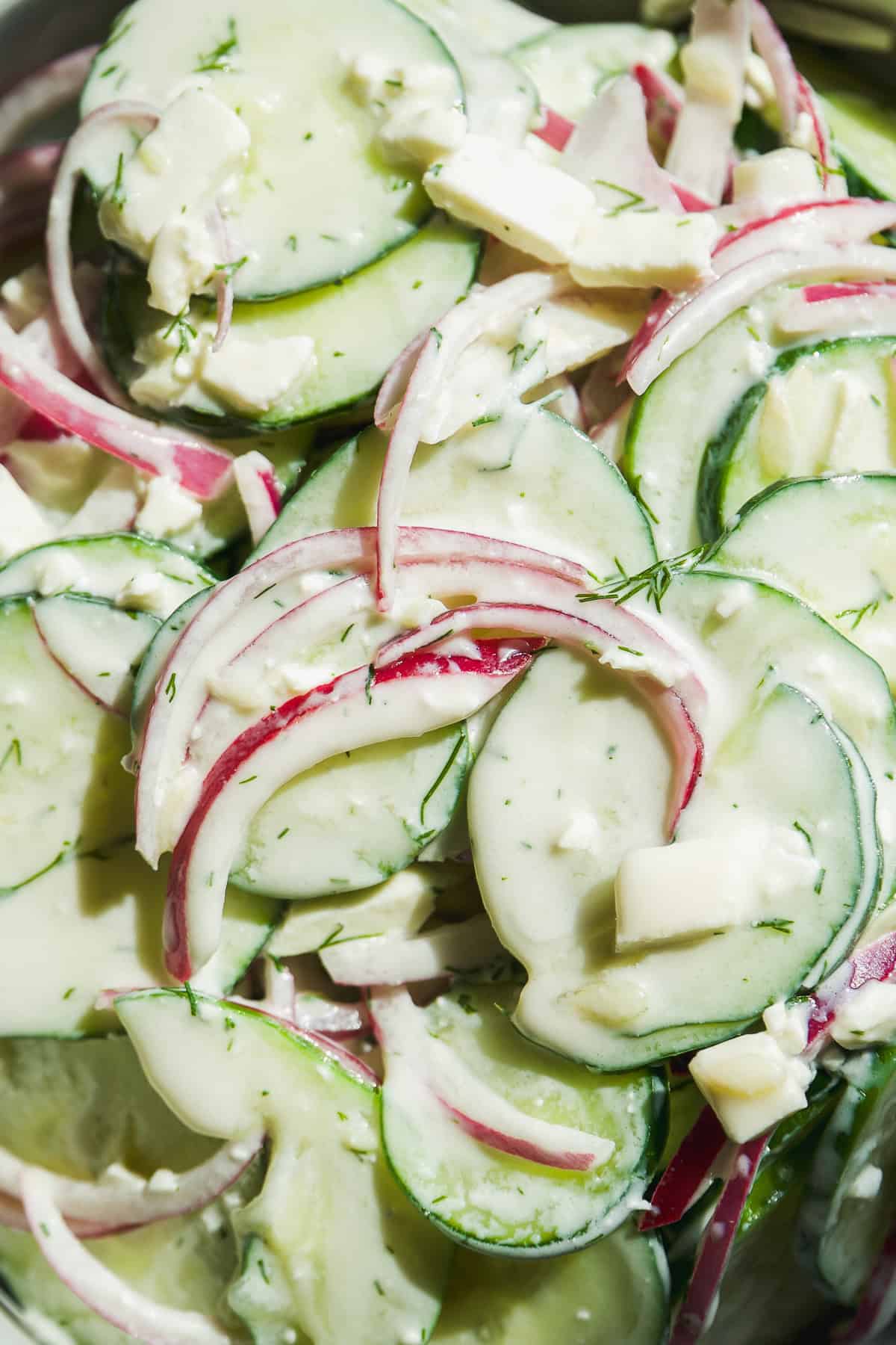 Up close view of cucumber salad with feta cheese.