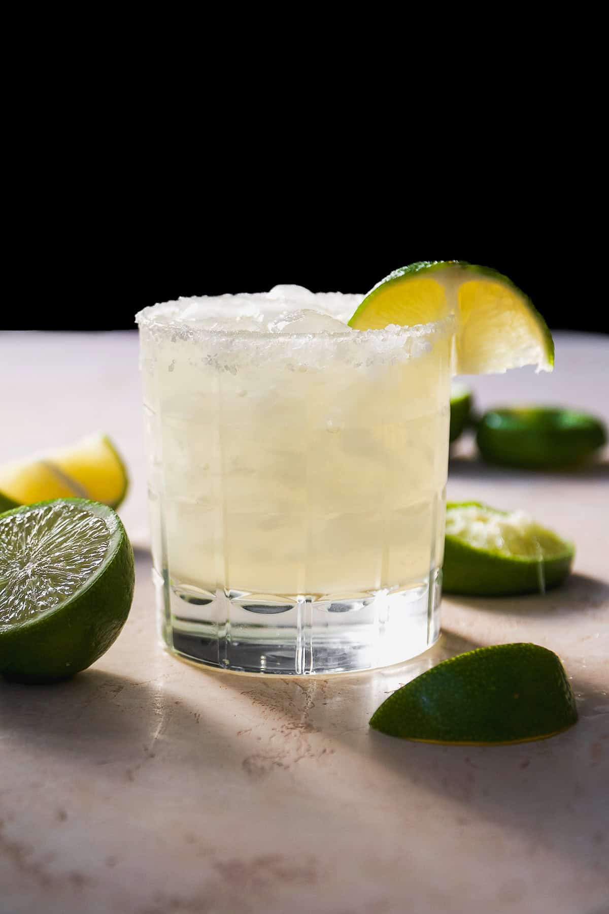 Margarita on a table with a lime wedge.