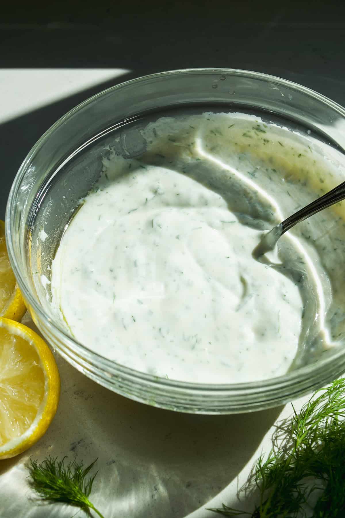 Dill yogurt sauce in a glass bowl.