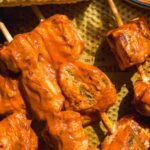 Bbq chicken skewers on a pan with corn.