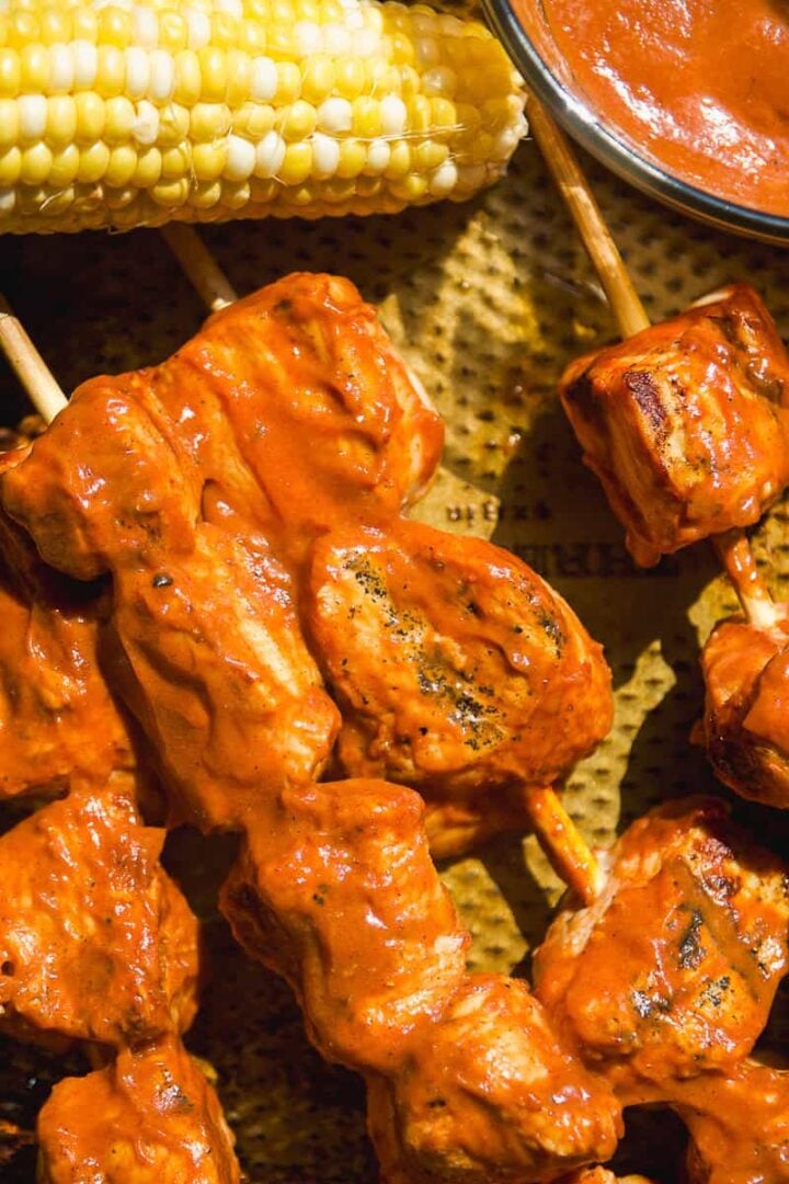Bbq chicken skewers with sauce on a pan.