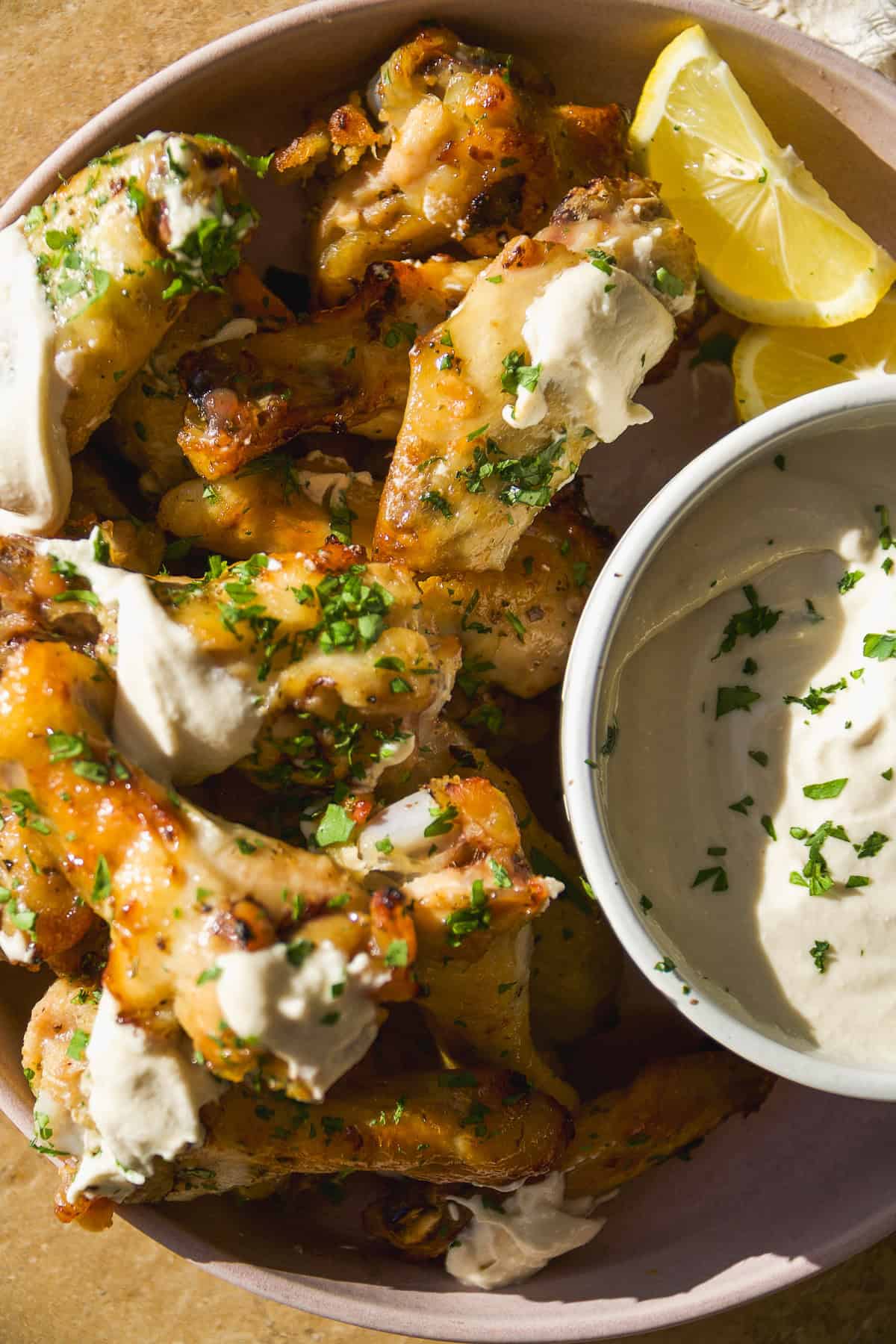 Greek chicken wings with feat sauce in a bowl.