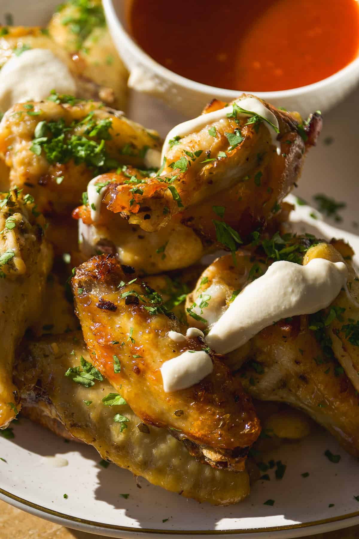 Greek healthy chicken wings on a platter with feta sauce.