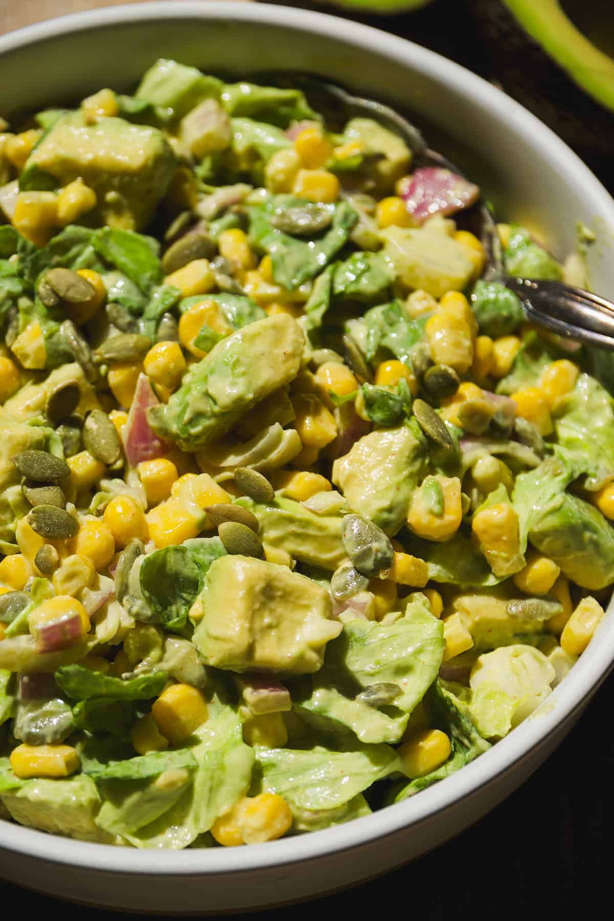 Avocado and corn salad tossed with lettuce and greek yogurt mustard dressing.