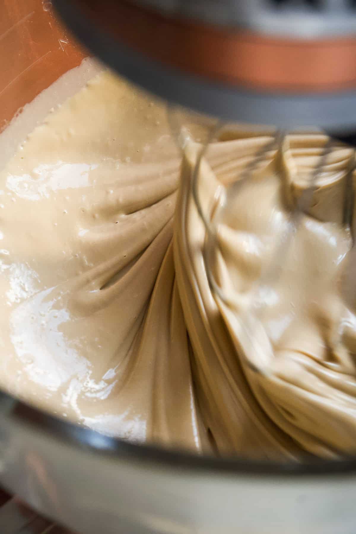 Maple syrup being whisked into maple butter in a stand mixer.