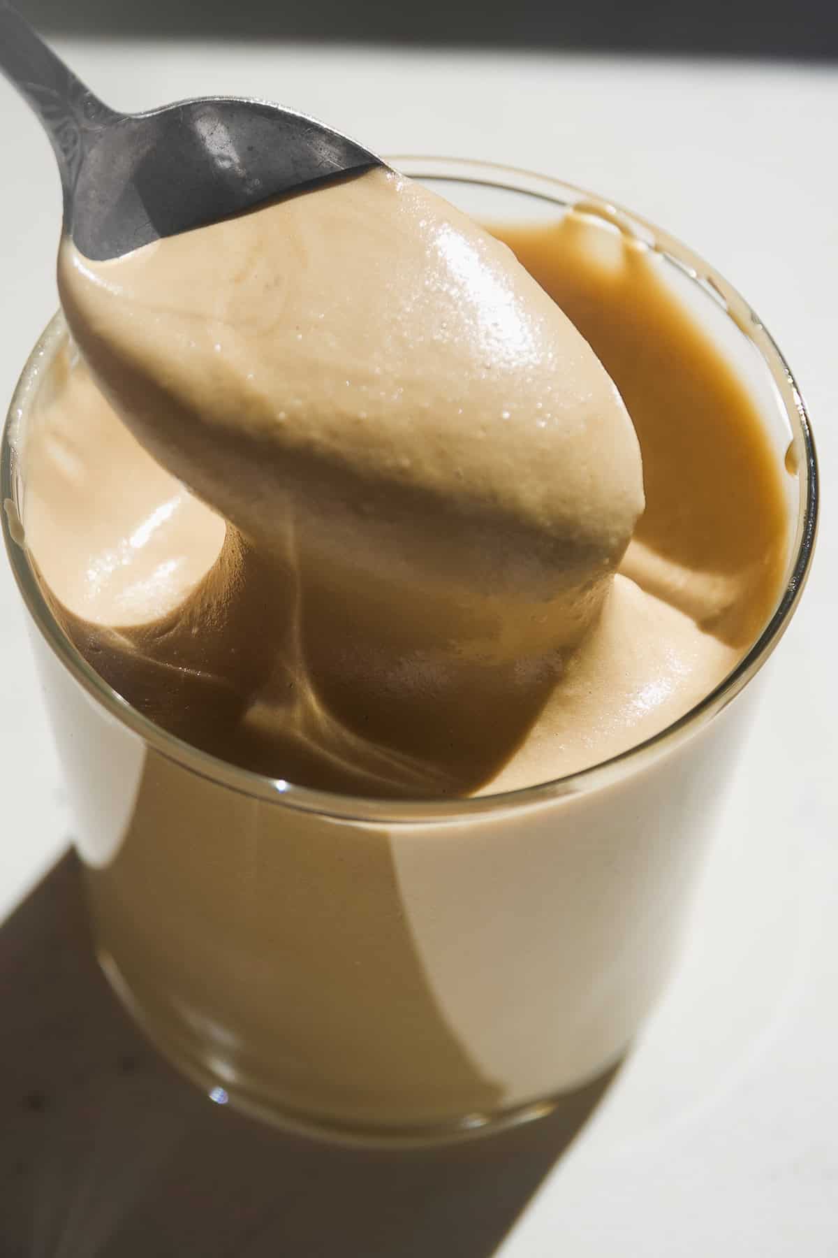 Maple cream in a jar with a spoon dipping inside.