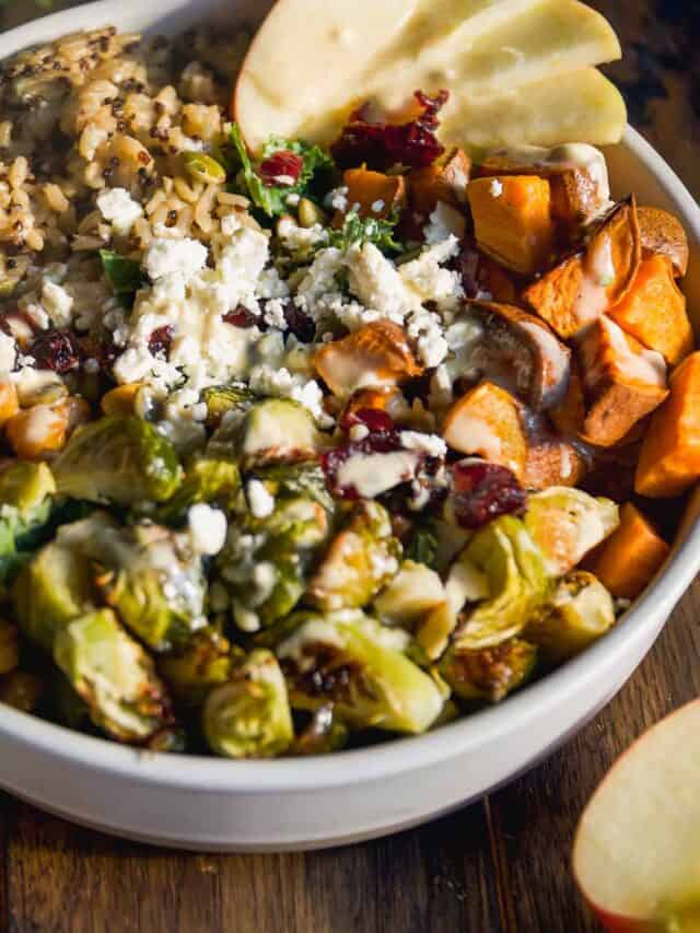 Harvest bowl salad with sweet potatoes, brussel sprouts, rice, feta, apples, and more.