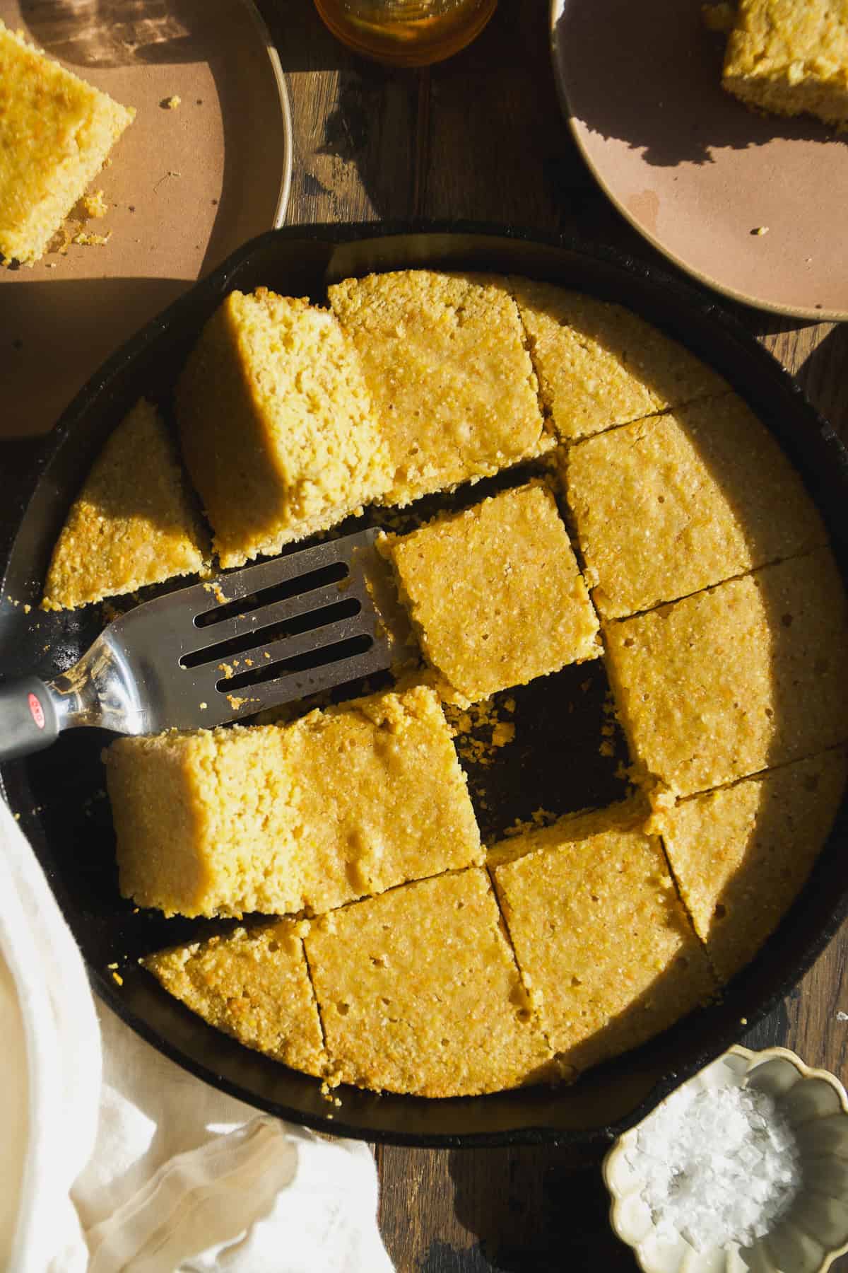 Gluten free cornbread in a skillet cut into pieces.