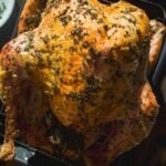 Overhead view of an herb roasted turkey in a pan.