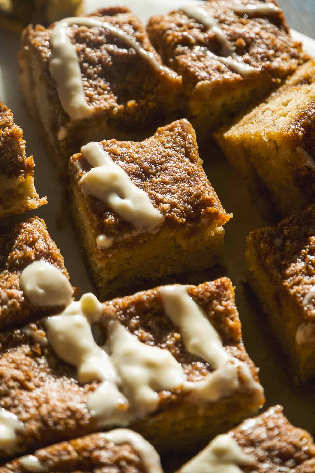 Banana bread coffee cake cut into squares with icing.